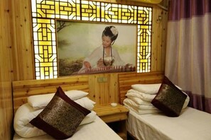 Quarto com paredes de madeira, uma pintura tradicional chinesa e duas camas com almofadas estampadas.