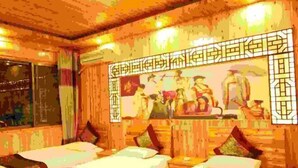 A room with wooden walls, a mural, and four beds with pillows. - Likeng Yuelai Inn (Wuyuan)
