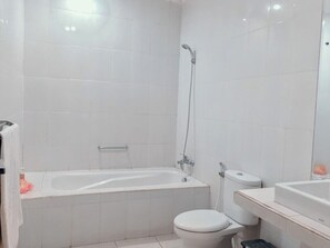 A modern bathroom with a bathtub, toilet, and sink. - Wana Ukir (Sukawati)