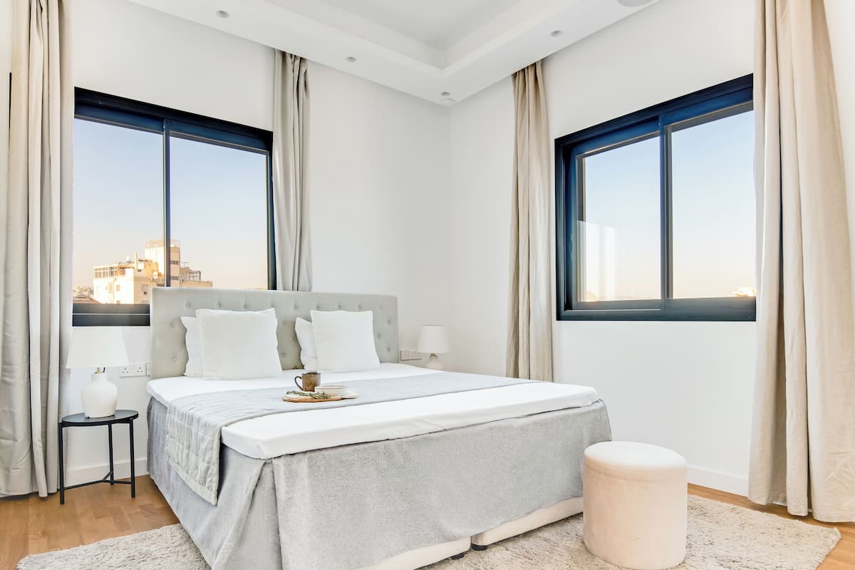 Relax in a stylish room with a large bed, bedside table, and city view.