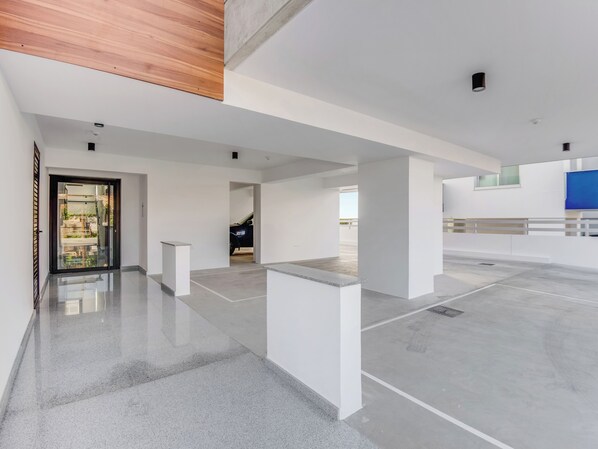 A spacious, modern interior with a polished concrete floor, white walls, and a wooden ceiling. - Sanders Crystal 2 Limassol (Limassol)