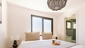 A hotel room with a large bed, two bedside tables with lamps, a window with a view, and a bathroom visible through an open door. - Sanders Crystal 2 Limassol (Limassol)