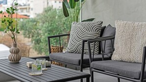 A balcony with a sofa, a table, and a potted plant. - Sanders Crystal 2 Limassol (Limassol)