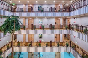 A multi-level atrium with balconies, staircases, and potted plants. - Jibolong Hotel (Lijiang)