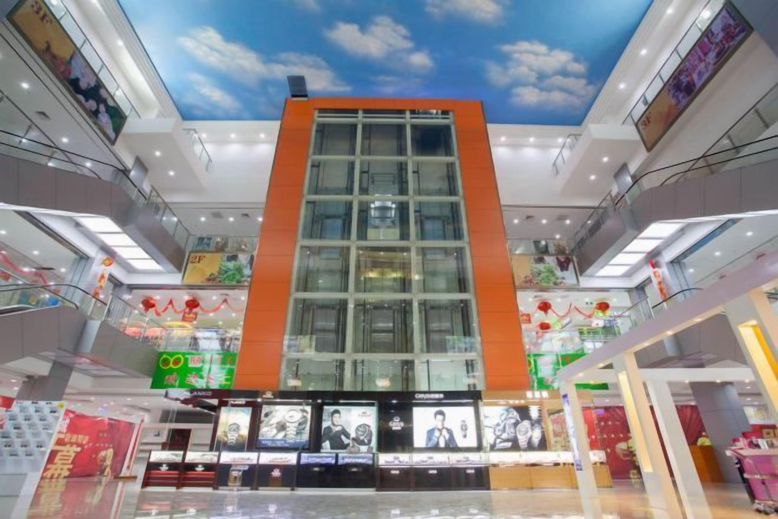 Un centre commercial à plusieurs niveaux, doté d’un atrium central, d’escalators et de divers magasins.