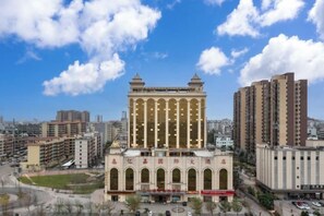 A large building with a central arched entrance and multiple floors. - Yijia International Hotel (Wenchang)