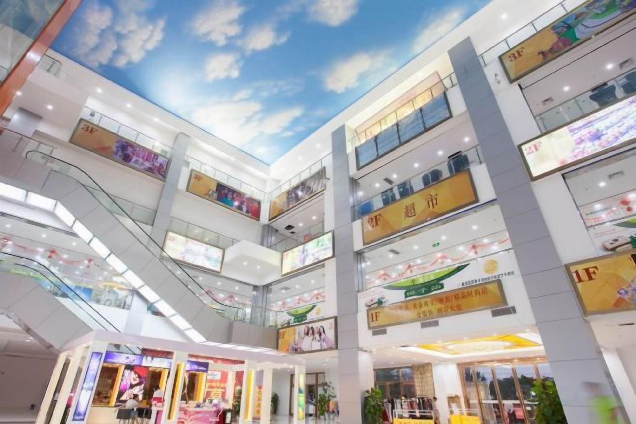 A multi-level shopping mall with escalators, retail stores, and a central atrium.