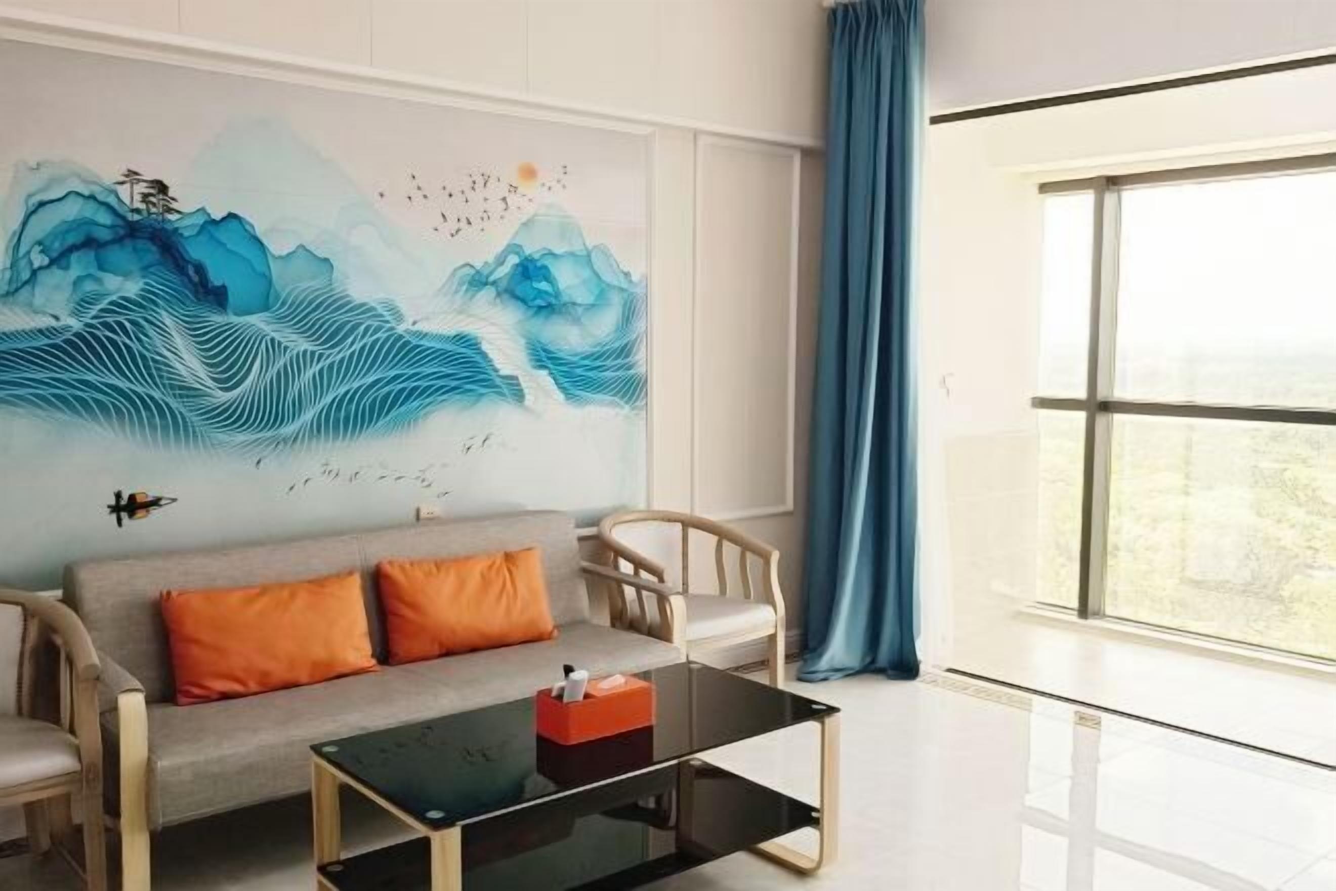 Un salon moderne avec un canapé, des fauteuils, une table basse en verre et une grande fenêtre avec des rideaux.