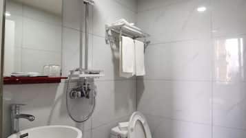 A bathroom with a sink, toilet, shower, and a towel rack.
