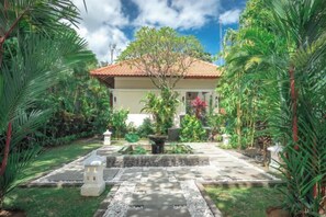 A house with a tiled roof, surrounded by lush greenery and a well-maintained garden. - Villa Mata Hari (Bali)