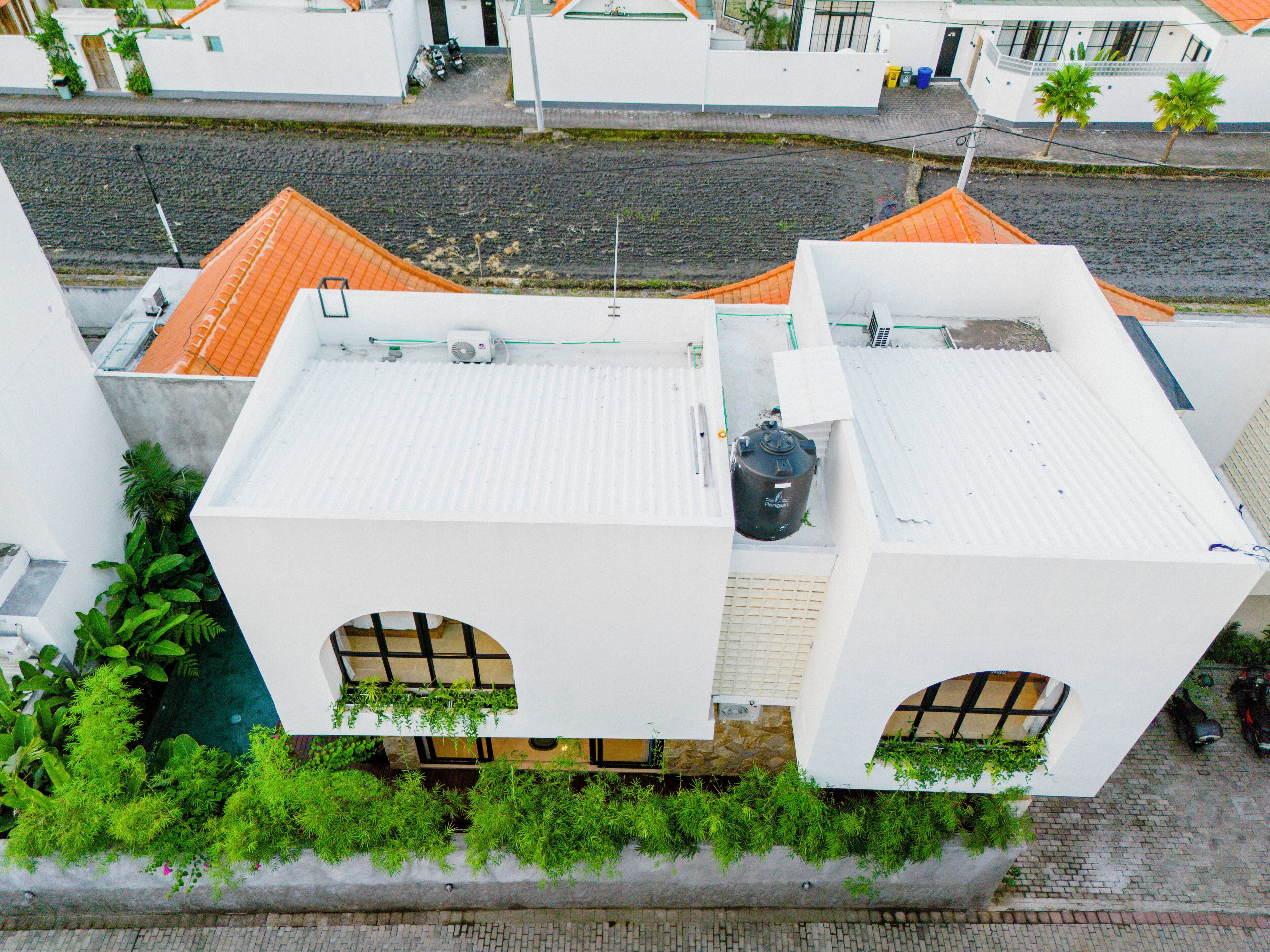 A building with a white facade, two arched windows, and a tiled roof.