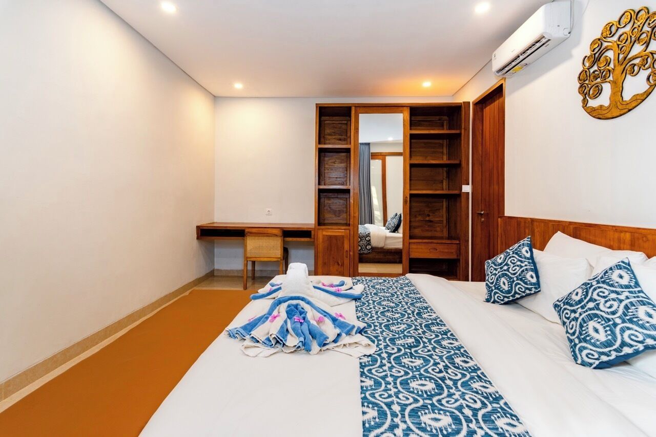 Ein Hotelzimmer mit Bett, Schreibtisch, Stuhl und Kleiderschrank.