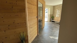 A hallway with wooden walls, a bench, and a plant.