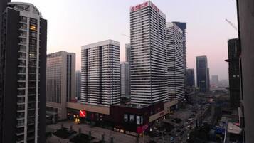 A cityscape with high-rise buildings, a busy street, and a clear sky.