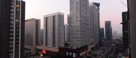 A cityscape with high-rise buildings, a busy street, and a clear sky.
