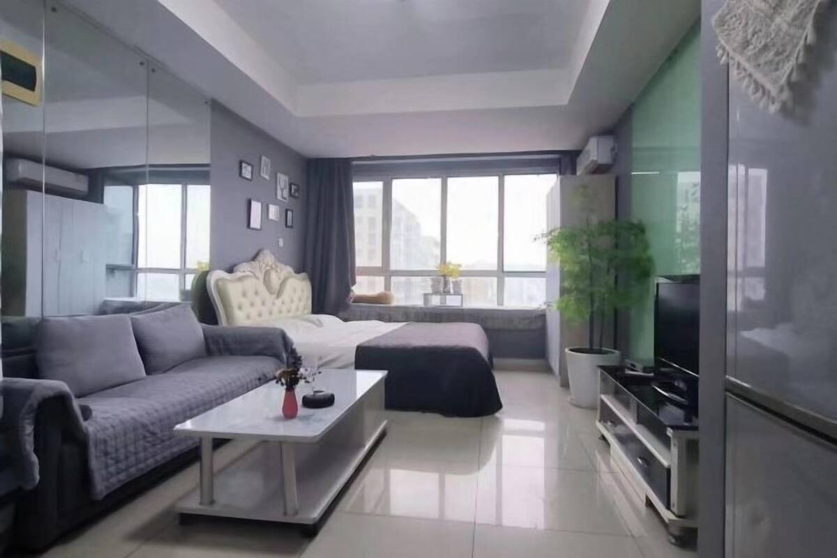 A modern living room with a sofa, coffee table, and a television.
