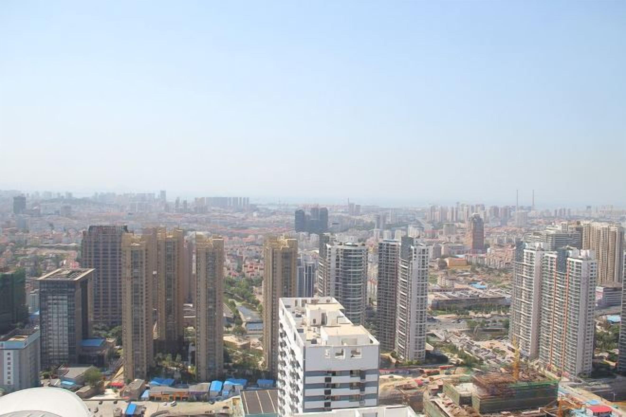 Un complejo de edificios de gran altura con varias estructuras residenciales y comerciales, rodeado por un paisaje urbano.