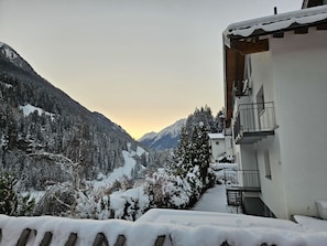 Schneebedeckte Berglandschaft mit einem Gebäude, das Balkone und einen Blick auf das Tal bietet.