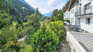 A residential building with a balcony, surrounded by lush greenery and a mountainous backdrop. - Sonnenseite by Interhome (Kappl)