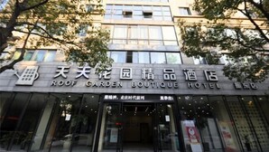 The exterior of the Roof Garden Boutique Hotel with a clear entrance and signage in both English and Chinese.