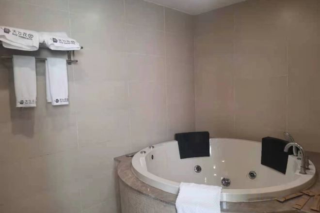 A bathroom with a freestanding bathtub, a towel rack with towels, and a shower area.