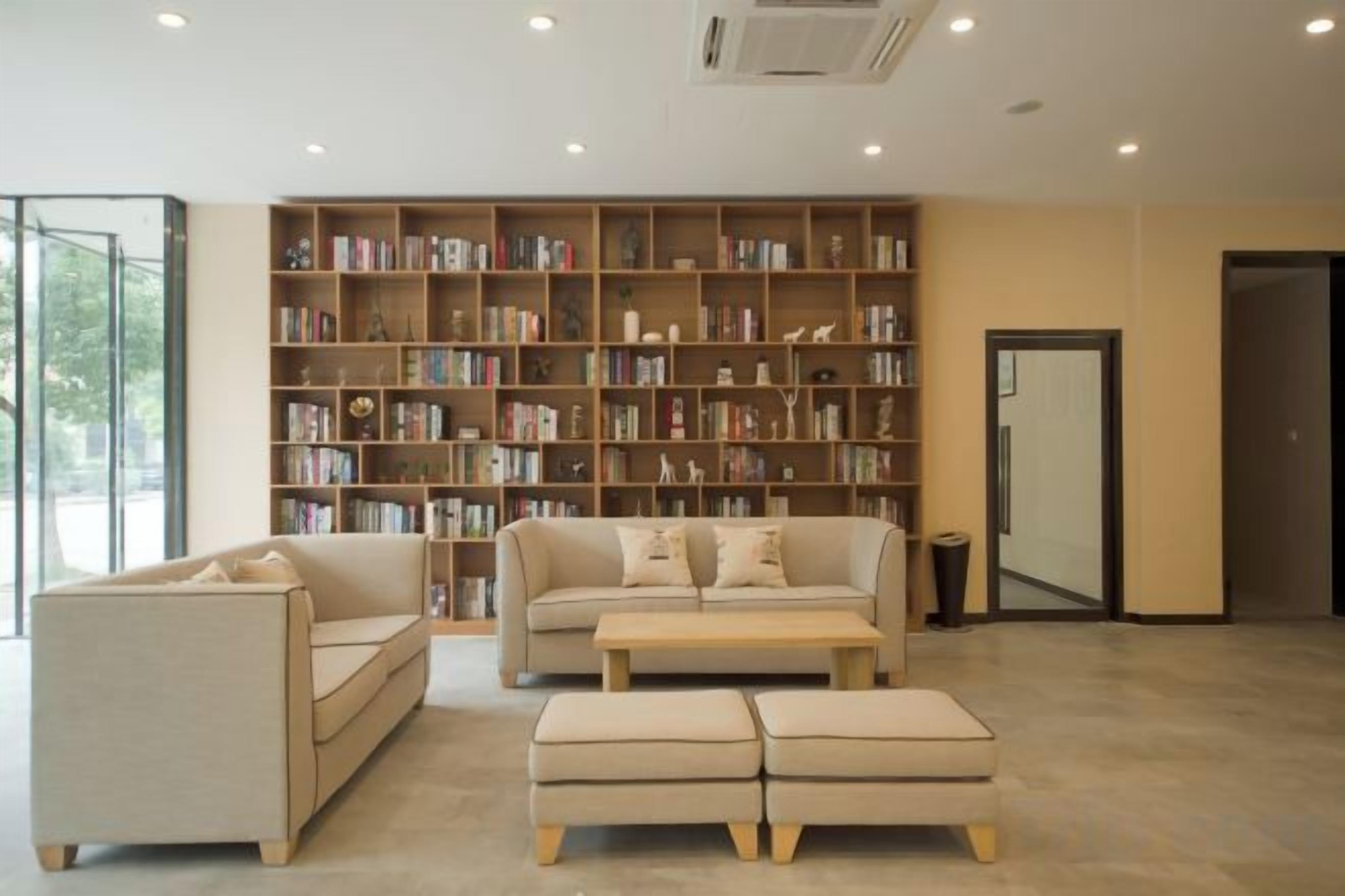 A spacious room with a large bookshelf, a sofa, and a coffee table.