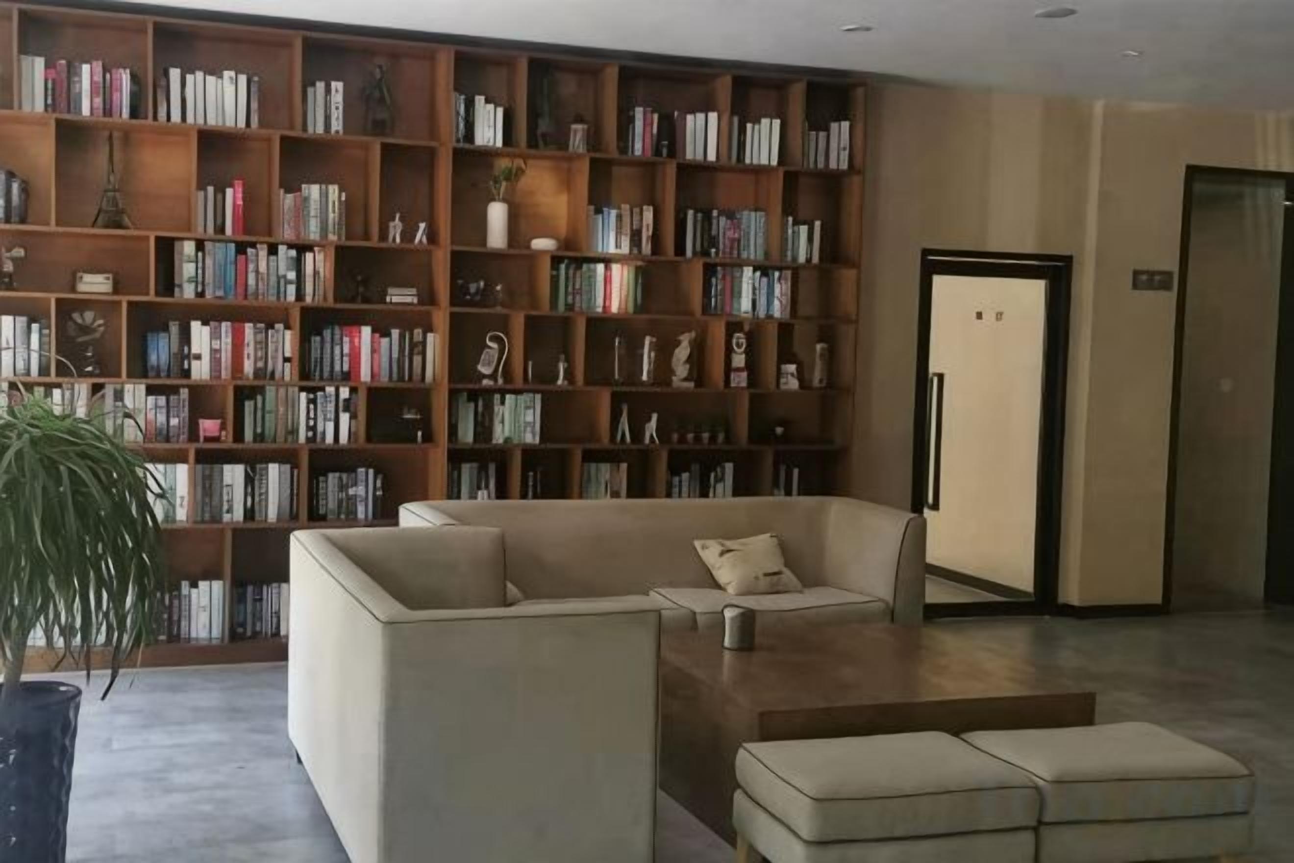 Una biblioteca con estanterías, un sofá y una mesa de centro.