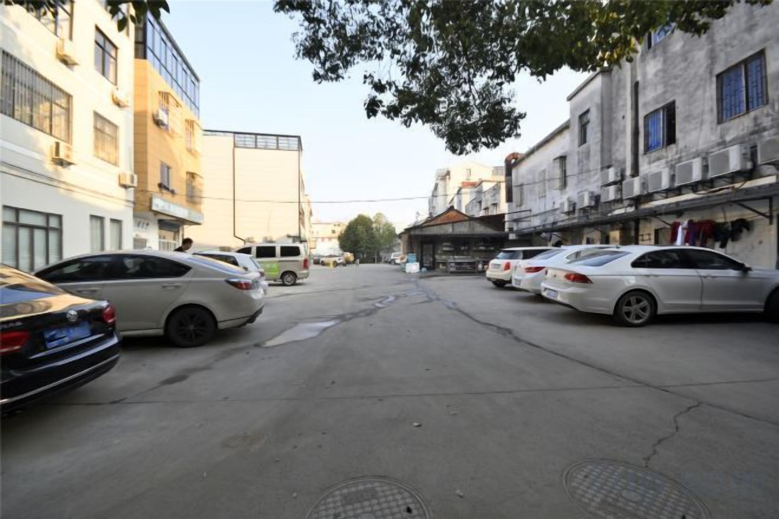 Una calle con coches aparcados y edificios.
