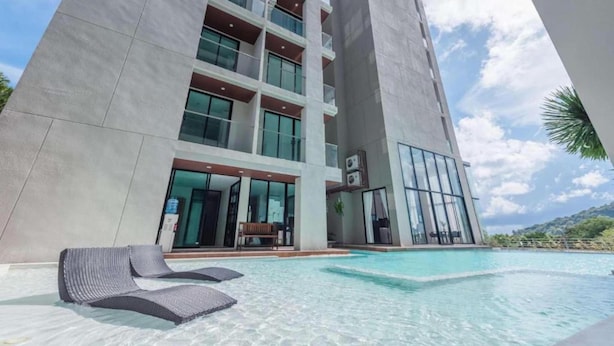 A modern hotel with a swimming pool, multiple balconies, and a view of the surrounding landscape. - Tropical View Suite A603 at Viva Patong (Patong)