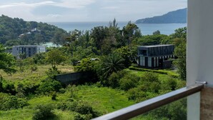 A view of a coastal area with modern buildings, lush greenery, and a clear view of the sea. - Tropical View Suite A603 at Viva Patong (Patong)