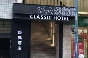 The entrance to Classic Hotel with a digital sign and a staircase leading up to the entrance. - Classic Hotel (Yuechi)