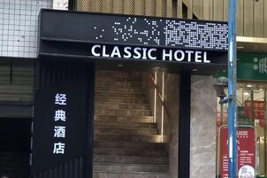 La entrada del Hotel Classic con un letrero digital y una escalera que lleva a la entrada.