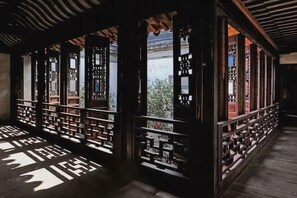 A traditional wooden structure with open sides, displaying shelves with items.