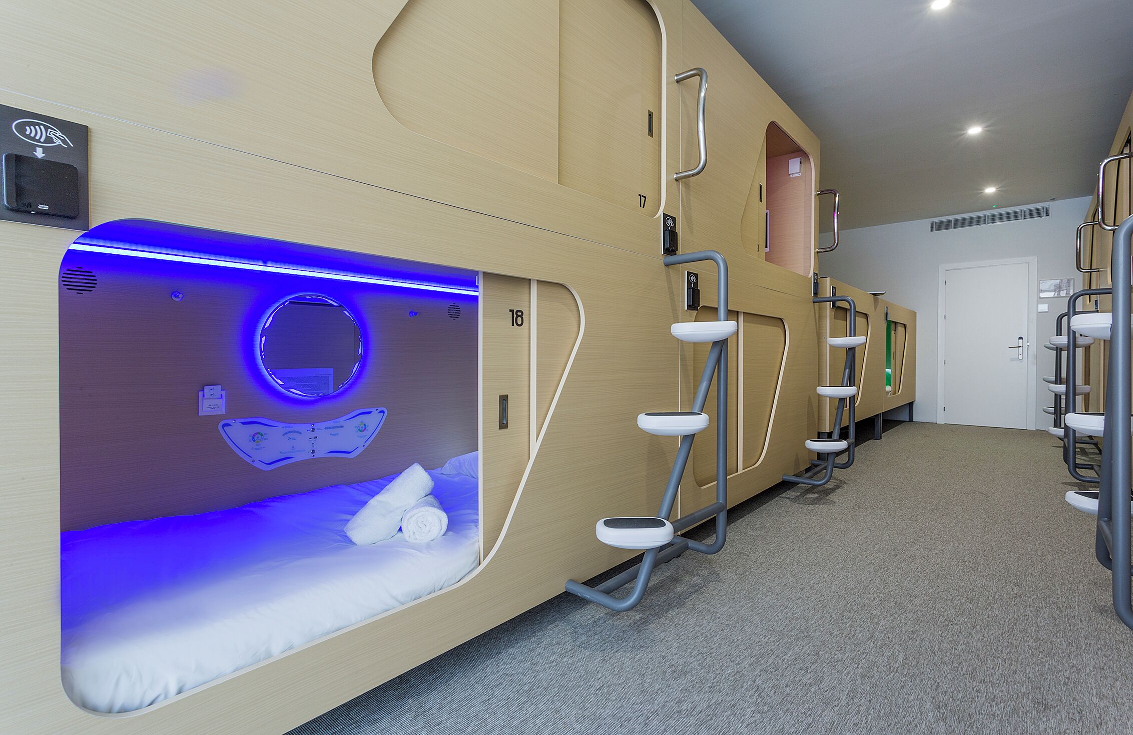 A hotel room with a bunk bed, a built-in massage chair, and a shower area.