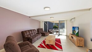 Una sala moderna con un conjunto de sofá, una mesa de centro y un televisor.
