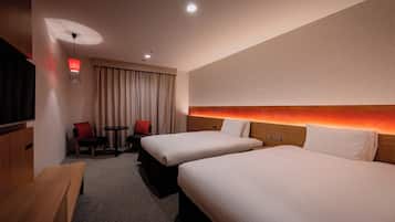 Habitació d'hotel amb dos llits, una televisió, una taula, una cadira i una làmpada.