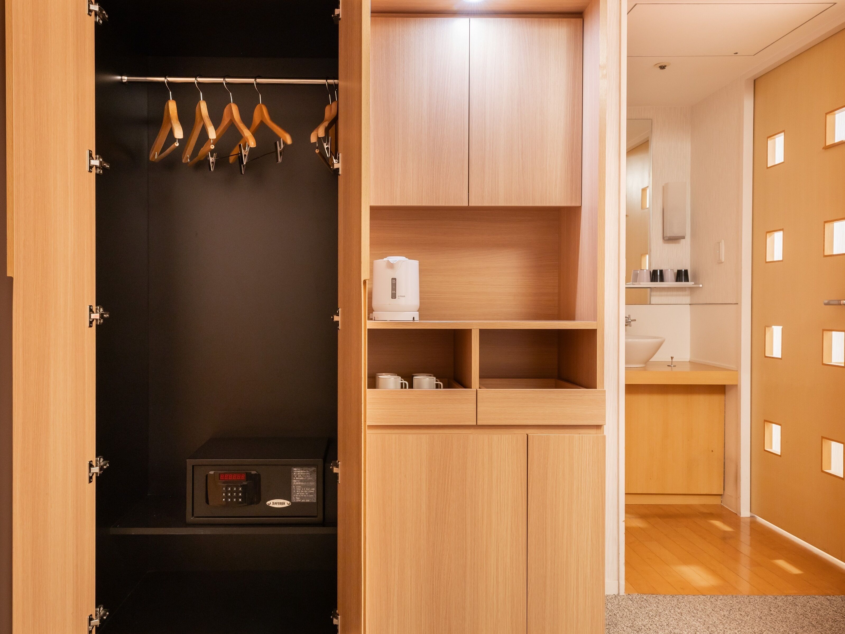 Un baño moderno con tocador de madera, lavamanos y espejo.