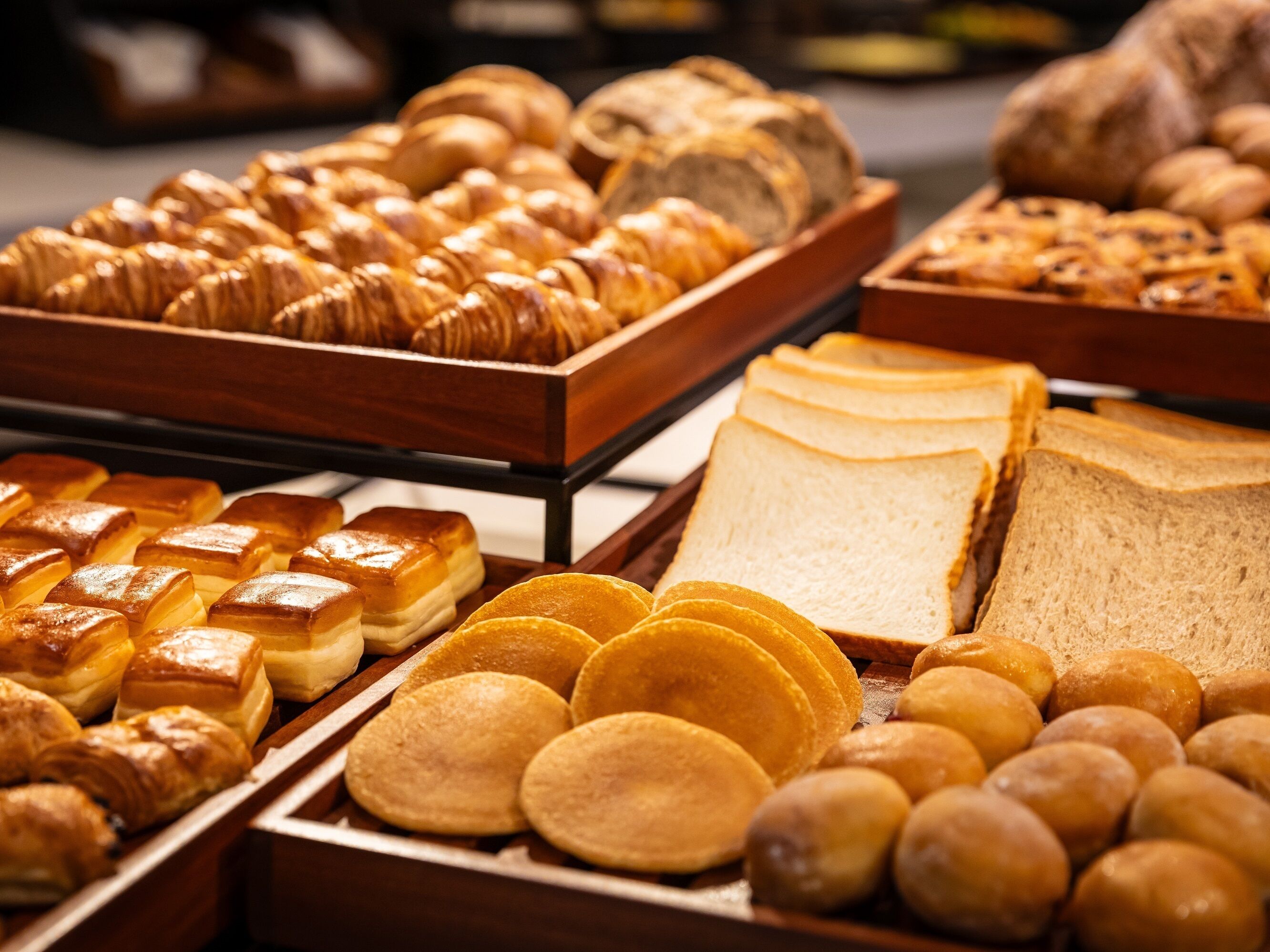 A bakery display with various baked goods including pastries, bread, and cakes.