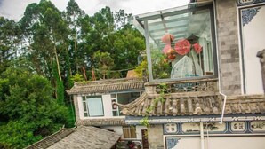 A traditional Chinese building with a wooden balcony and a glass enclosure. - Fushui Inn (Dali City)