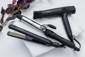 Quatro ferramentas para modelar o cabelo sobre uma toalha branca.