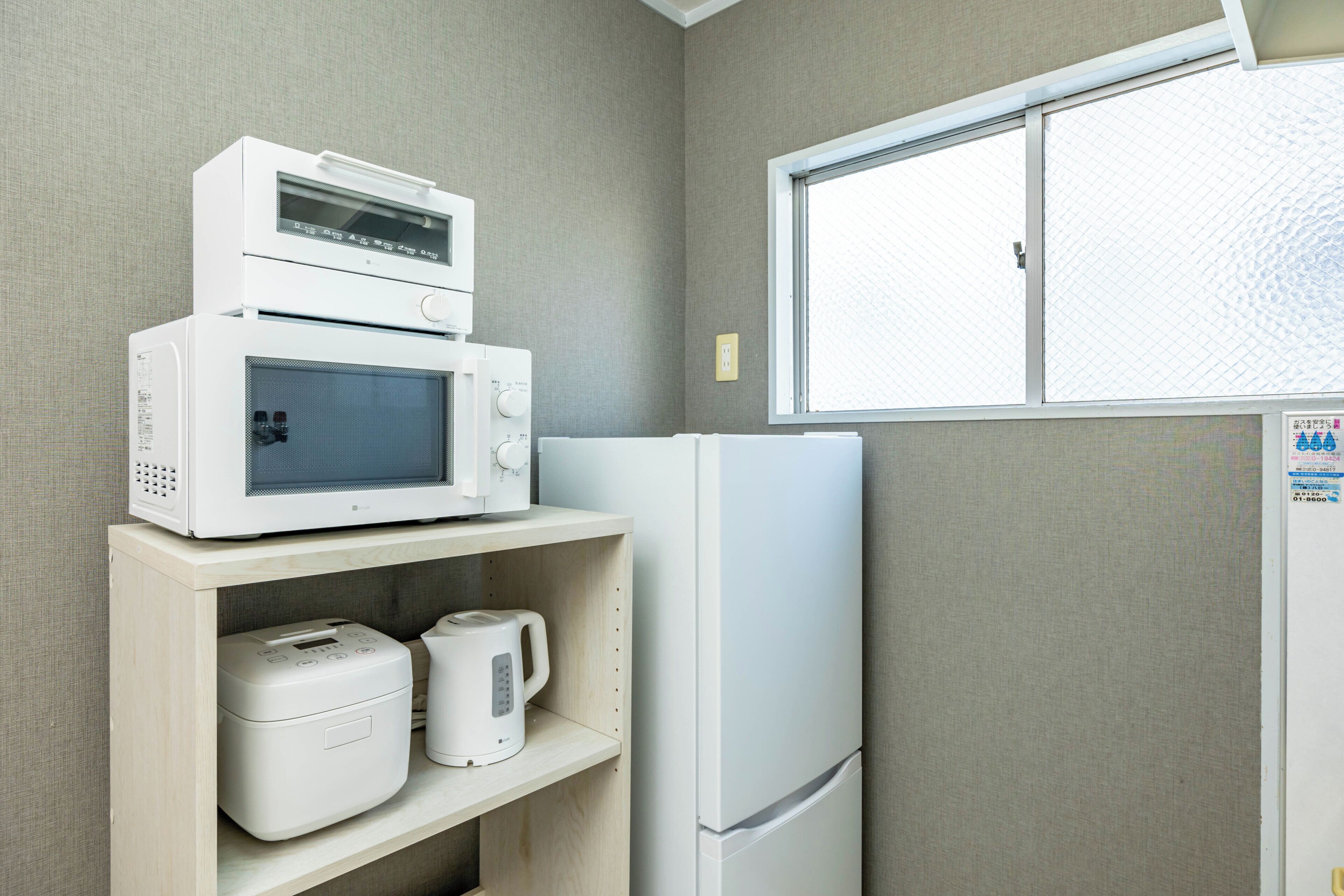 A kitchen with a microwave, toaster, and refrigerator.