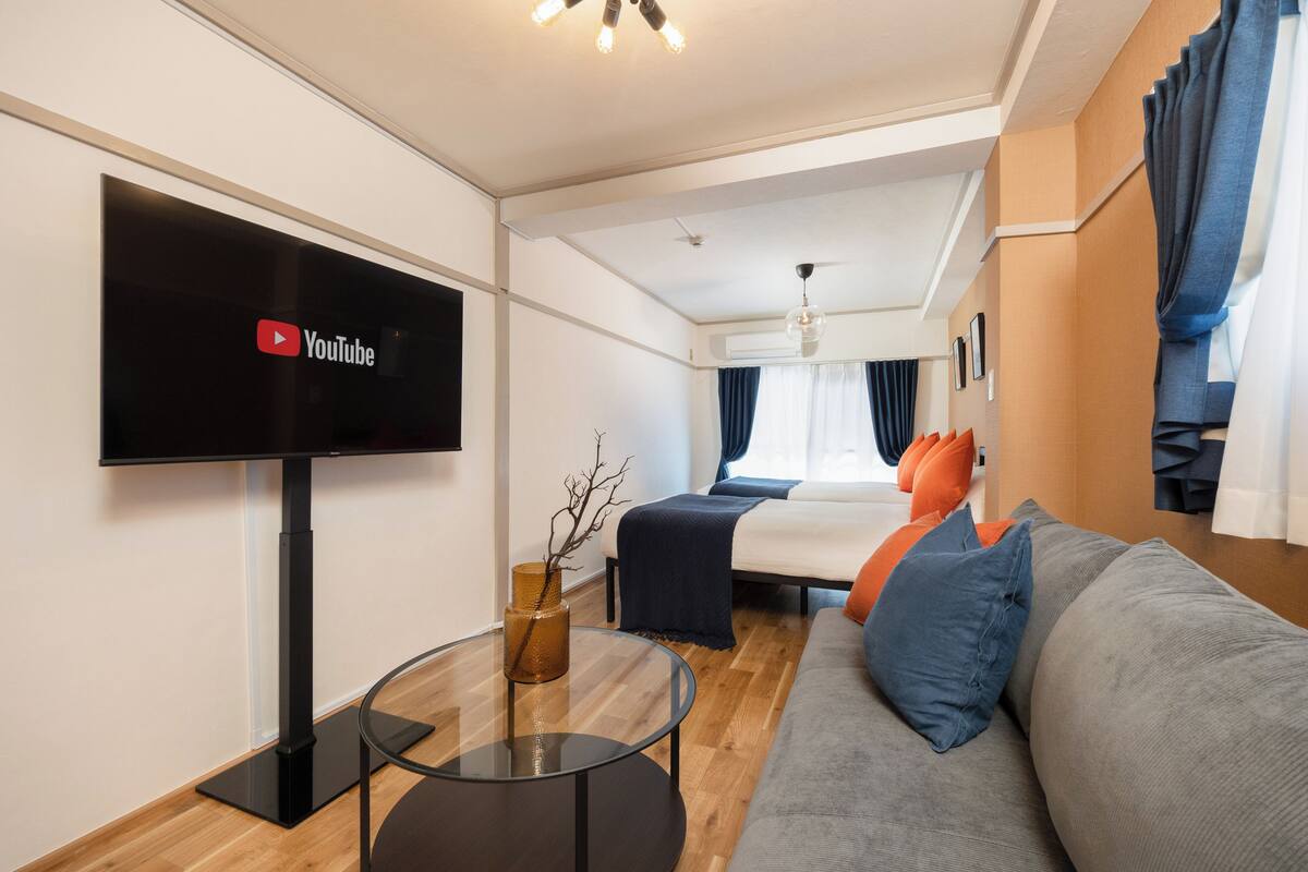 Une chambre d’hôtel moderne équipée d’une télévision à écran plat, d’un canapé, d’un lit et d’une petite table.