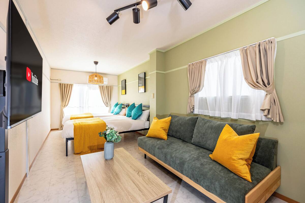 Une chambre d’hôtel moderne équipée d’un lit, d’un canapé, d’une télévision et d’un coin repas.