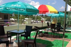 Terras met parasols, een met bestrating en uitzicht op de omgeving.