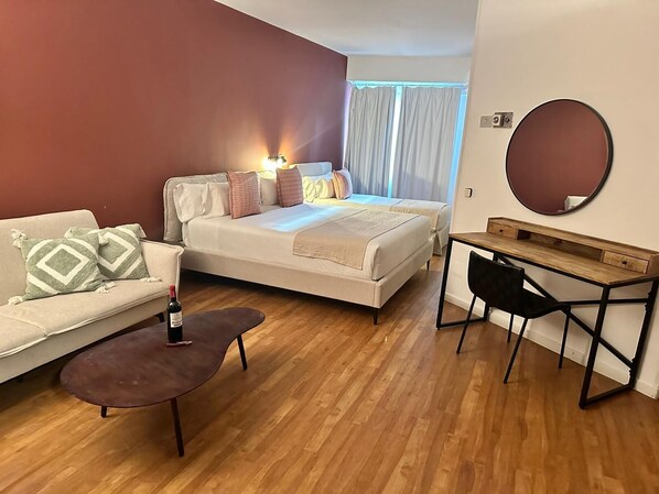 Una habitación de hotel con una cama, un sofá, un escritorio y una silla.
