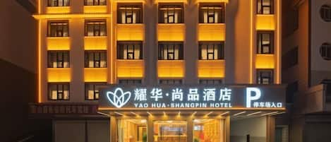 A hotel with a modern facade, multiple floors, and illuminated windows.