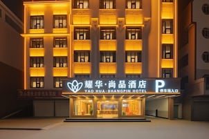 Un hotel de varios pisos, con una entrada destacada y señalización iluminada.
