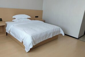 A modern hotel room with a single bed, a bedside table, and a nightstand. - Balikun Hancheng Hotel (Barkol)