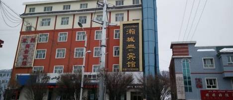 A multi-story building with a prominent sign for a hotel.