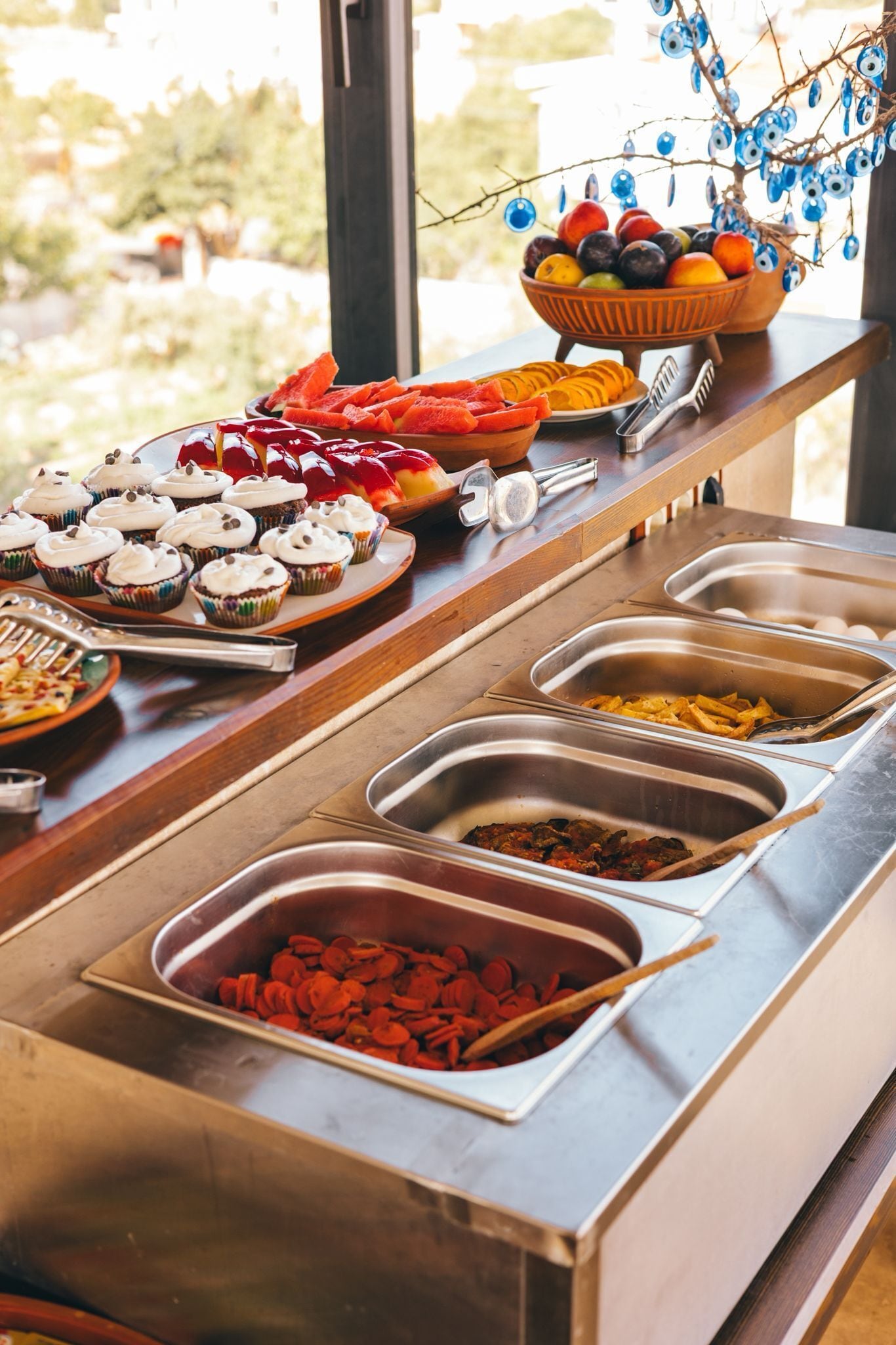 Un buffet proposant une variété de plats et une branche décorative ornée de décorations bleues.